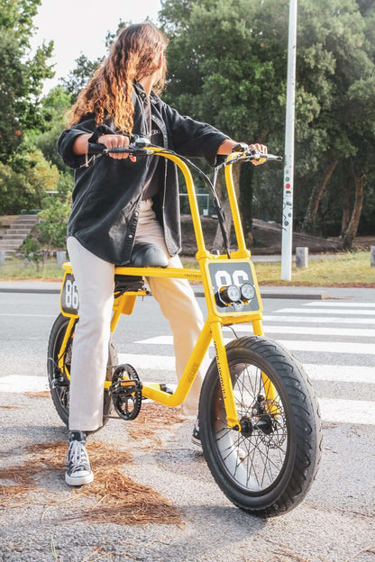 vrouwelijk-model-zittend-op-de-gele-voltaway-passenger-fatbike