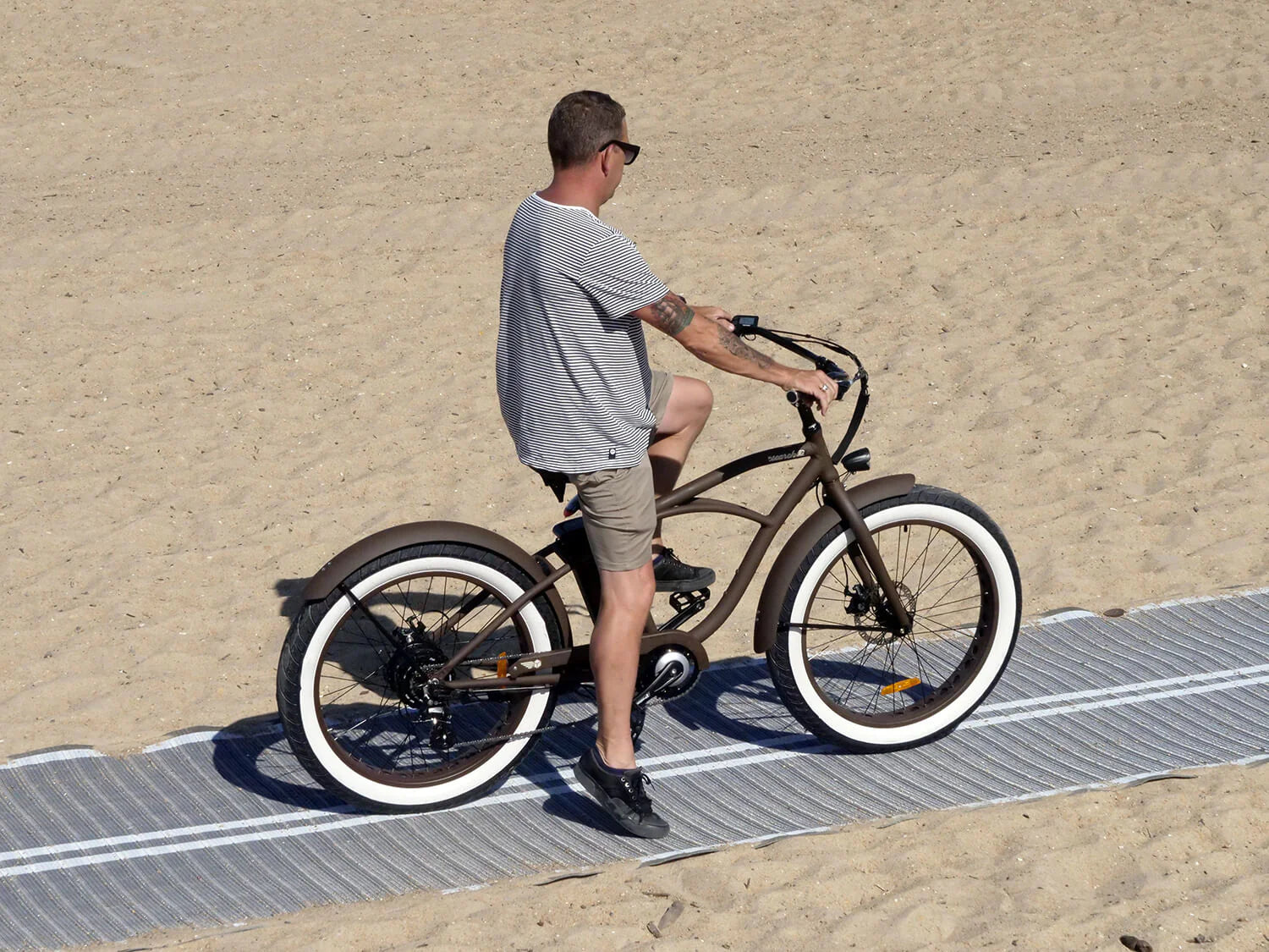 mannelijk-model-zittend-op-bruine-fatbike-genaamd-voltaway-beach-cruiser-met-mannelijke-eigenschappen,-gefotografeerd-vanaf-de-zijkant
